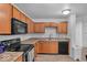 Galley kitchen features wooden cabinetry, a stainless sink, and modern appliances at 951 Curlew Ln, Greenwood, IN 46143
