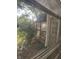 View of the sunny and green backyard from behind a mesh screen at 9550 N Delaware St, Indianapolis, IN 46240