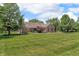 Charming brick home with an expansive front lawn and lush, mature trees at 10174 N County Road 471 E, Pittsboro, IN 46167