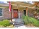 Covered front porch with brick facade, wooden support posts, and steps leading to the front door at 10174 N County Road 471 E, Pittsboro, IN 46167