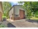 Large garage features a brown garage door and exterior door, set back from driveway at 10174 N County Road 471 E, Pittsboro, IN 46167