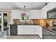 A bright kitchen with white cabinetry, stone backsplash, and stainless steel appliances at 10174 N County Road 471 E, Pittsboro, IN 46167