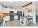 Bright eat-in kitchen with stone backsplash, island with seating, and stainless steel appliances at 10174 N County Road 471 E, Pittsboro, IN 46167