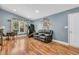 Spacious living room featuring a comfortable black couch, a window with natural light, and hardwood floors at 10174 N County Road 471 E, Pittsboro, IN 46167