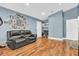 Comfortable living room has hardwood floors, a black couch, and unique wall decor at 10174 N County Road 471 E, Pittsboro, IN 46167