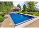 A bright blue inground pool sits on a concrete patio surrounded by lush green grass at 10174 N County Road 471 E, Pittsboro, IN 46167