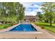 A bright blue inground pool is surrounded by a concrete patio and green trees at 10174 N County Road 471 E, Pittsboro, IN 46167