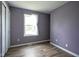 This bedroom features stylish light-gray walls and wood-look floors, complemented by a window and white trim at 10751 Sheffield Ct, Fishers, IN 46038