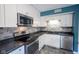 Modern kitchen featuring stainless steel appliances, white cabinetry, stone backsplash, and a stylish countertop at 10751 Sheffield Ct, Fishers, IN 46038