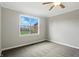 A cozy bedroom with plush carpet, gray walls, white trim, and a window that brings in natural light at 1127 Kay Dr, Greenwood, IN 46142