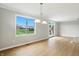 Open dining area boasts hardwood floors, natural light, and a modern chandelier, perfect for entertaining and Gathering meals at 1127 Kay Dr, Greenwood, IN 46142