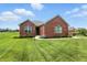 Beautiful red brick home with a well-manicured lawn and landscaping, under a blue sky with clouds at 1127 Kay Dr, Greenwood, IN 46142