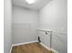 This laundry room features wood floors, gray walls, a washing machine hookup, and wire shelving for storage at 1127 Kay Dr, Greenwood, IN 46142