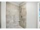 Tiled shower stall features a hand-held shower head, a corner shelf, and neutral colored tiles at 1127 Kay Dr, Greenwood, IN 46142