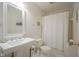 This bathroom offers a pedestal sink, toilet, and a shower with white curtain at 11624 Buttonwood Dr, Carmel, IN 46033
