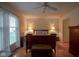 Bedroom with wood floors, dresser, trunk at the foot of the bed, and window with blinds at 11624 Buttonwood Dr, Carmel, IN 46033