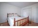 This bedroom features a wood frame bed, wood floors, and closet with white doors at 11624 Buttonwood Dr, Carmel, IN 46033