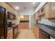 Functional kitchen with wood cabinetry, black appliances, and wood floors at 11624 Buttonwood Dr, Carmel, IN 46033
