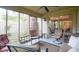 Enclosed porch with comfortable seating, screened windows, fan, and view of the backyard at 11624 Buttonwood Dr, Carmel, IN 46033