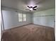 Spacious bedroom featuring ceiling fan, large window, and plush carpeting at 1206 Brownswood Dr, Brownsburg, IN 46112