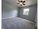Bedroom with ceiling fan, soft carpet, and a bright window at 1206 Brownswood Dr, Brownsburg, IN 46112