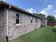 Angle shot of a beautiful brick house with white framed windows and green lawn at 1206 Brownswood Dr, Brownsburg, IN 46112