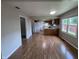 Open-concept kitchen and dining area with wood floors and natural light from window at 1206 Brownswood Dr, Brownsburg, IN 46112