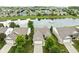 Aerial view of brick home overlooking pond with fountain, surrounded by lush landscaping and a well-manicured lawn at 13019 Pinner Ave, Fishers, IN 46037