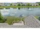 Backyard view overlooking a calm pond with a fountain, from a wooden deck with stairs at 13019 Pinner Ave, Fishers, IN 46037