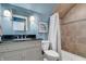 Charming bathroom showcasing a granite vanity, shower with decorative tilework, and blue walls at 14027 Waterway Blvd, Fishers, IN 46040