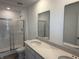 Bathroom featuring double sinks, a large mirror, a glass-enclosed shower, and modern fixtures at 1436 Aster Dr, Shelbyville, IN 46176