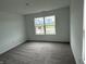 Bedroom with plush carpeting, neutral walls, and a large window allowing ample natural light at 1436 Aster Dr, Shelbyville, IN 46176