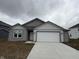 Charming one-story home featuring gray siding, a two-car garage, and a welcoming front entrance at 1436 Aster Dr, Shelbyville, IN 46176