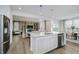 Open concept kitchen with stainless steel appliances, an island with quartz countertops and an adjacent dining and living area at 16485 Mount Logan Rd, Noblesville, IN 46060