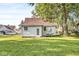 Back exterior of home with grassy yard, mature trees, and a fenced boundary at 2020 N B St, Elwood, IN 46036