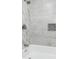 Close-up of a bathroom featuring stylish gray tile, a bathtub, and a shower niche at 2136 Ringgold Ave, Indianapolis, IN 46203