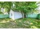 Backyard outbuilding surrounded by a lush lawn and mature trees, offering privacy and charm at 2136 Ringgold Ave, Indianapolis, IN 46203