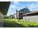 The backyard features lush green grass and mature trees surrounding the house at 2227 Hidden Orchard Ct, Indianapolis, IN 46228