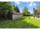 Spacious backyard featuring lush green grass, mature trees, and convenient shed for extra storage at 2227 Hidden Orchard Ct, Indianapolis, IN 46228