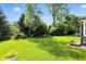 Green backyard featuring mature trees and lush green grass surrounding the property at 2227 Hidden Orchard Ct, Indianapolis, IN 46228
