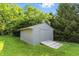Backyard featuring lush green grass, mature trees, and a convenient shed with ramp for easy storage at 2227 Hidden Orchard Ct, Indianapolis, IN 46228