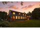 Exterior of two-story home at dusk, showing backyard, brick patio, and verdant green lawn at 2227 Hidden Orchard Ct, Indianapolis, IN 46228
