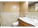 Tan tiled bathroom featuring a wood vanity with a white countertop and a decorative mirror at 2227 Hidden Orchard Ct, Indianapolis, IN 46228