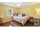Bedroom featuring wood flooring, a ceiling fan, a window, and a bed with decorative headboard and colorful linens at 2227 Hidden Orchard Ct, Indianapolis, IN 46228