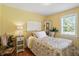 Bedroom featuring wood flooring, a lamp on the nightstand, a window, and a bed with colorful linens at 2227 Hidden Orchard Ct, Indianapolis, IN 46228