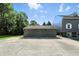A concrete driveway leads to a detached three-car garage with shade trees at 2227 Hidden Orchard Ct, Indianapolis, IN 46228