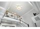 View of a staircase with white banister and a modern chandelier hanging overhead at 2227 Hidden Orchard Ct, Indianapolis, IN 46228