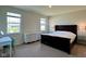 Bright bedroom featuring two windows, a dresser with ornate detail, a dark wood bed, and soft carpeting at 2232 Warbler St, Danville, IN 46122