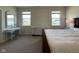 Bright bedroom featuring two windows, a dresser with ornate detail, a dark wood bed, and soft carpeting at 2232 Warbler St, Danville, IN 46122