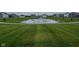 A serene pond with a fountain is surrounded by a manicured lawn in the community at 2232 Warbler St, Danville, IN 46122